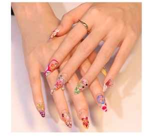 Détail d'ongles 3D à fleurs tropicales avec papillons, perles et cristaux brillants