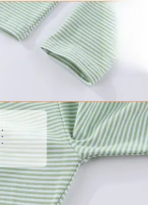 Detail view of green striped girls leggings with delicate floral embroidery on cuffs