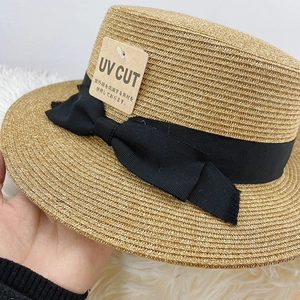 Nahaufnahme Strohhut mit schwarzer Schleife und UV-Schutz-Hängeetikett für Damen