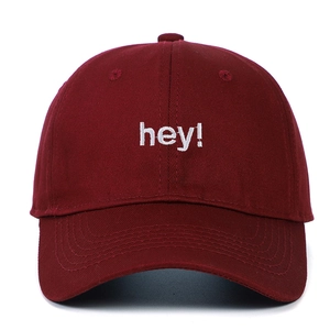 Détail de la broderie 'hey!' sur une casquette de baseball bordeaux en coton sergé