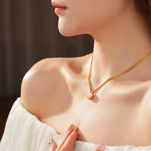 Détail d'un collier à double pendentif en forme de cœur plaqué or sur un mannequin