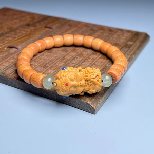 Handcrafted sandalwood bead bracelet with carved lotus charm and jade accents