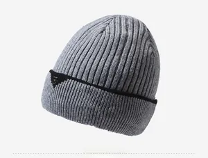 Detail view of the gray knitted beanie showing the thick texture and side shield logo
