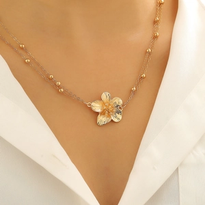 Detail van de boheemse gouden dubbellaagse lichaamsketting met bloem hanger
