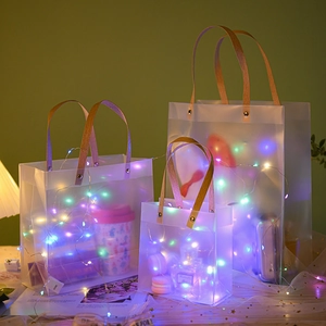 Frosted transparent PP gift bags with wood grain handles and rivet detail in three sizes