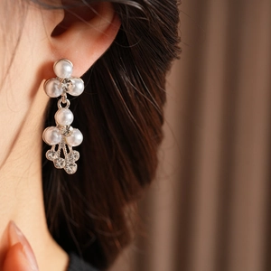 Gros plan de longues boucles d'oreilles de mariée avec perles et strass brillants
