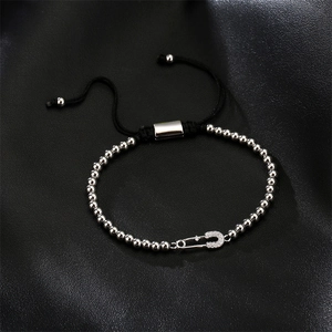 Detail of silver beaded bracelet with zircon safety pin pendant on adjustable black cord