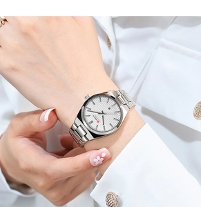 Close-up of a silver stainless steel watch with white grid dial on a woman's wrist