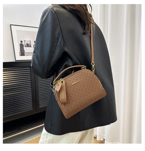 Brown vintage crossbody bag with brand logo texture shown on a model in a stylish setting