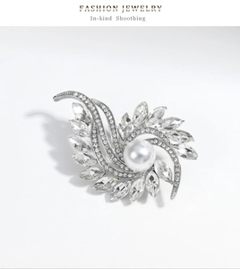 Detailed macro view of silver flower brooch with large pearl and shimmering marquise crystals