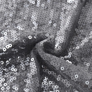 Detailopname van glanzende zilveren pailletten op gaasstof met textuur en reflectie