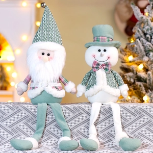 Detailed knit texture of Santa and Snowman plush dolls in sage green and checkered patterns