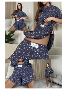 Detailed close-up of dark blue pajama set with heart prints and ruffled hem shorts