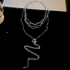 Elegant multi-layer beaded Y-necklace with a sparkling zircon cross pendant on black background