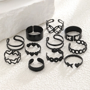 Flat lay of 11-piece black alloy ring set featuring heart and butterfly cutout designs
