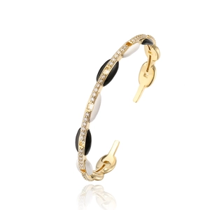 Dettaglio macro del bracciale placcato oro con smalto bianco e nero e zirconi