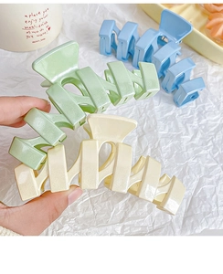 Détail de grandes pinces à cheveux à paillettes en vert pastel, blanc et bleu clair
