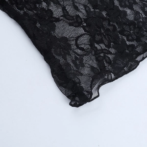 Detailed macro view of black lace fabric with floral embroidery and mesh cutout texture
