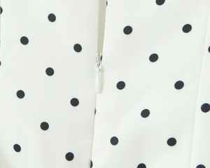 Detail of high-quality invisible zipper and black polka dot pattern on white fabric