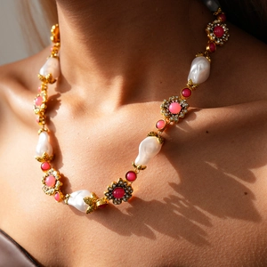 Detailed close-up of vintage flower necklace with baroque pearls and pink gemstones