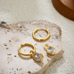 Macro shot of 18K gold-plated oval clear zircon charm on a stainless steel earring hoop