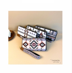 Detailed view of bohemian geometric pattern purses with golden zippers and wrist straps