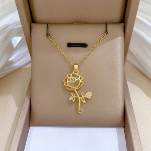 Detail of gold rose pendant necklace with cat-eye stone in a beige velvet gift box