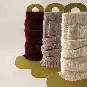 Jambières tricotées en rouge, beige et crème avec des motifs en losange gaufrés