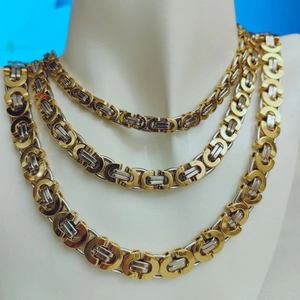 Detailed layered view of gold and silver Byzantine chain necklaces on a mannequin