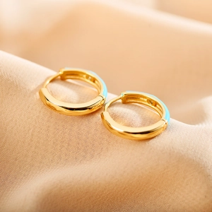 Macro shot of gold-plated hoop earrings with light blue enamel and sparkling rhinestones