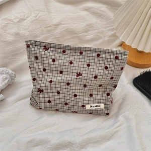 Dettaglio della trousse per cosmetici a pois con cerniera ed etichetta Sozakka