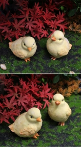 Realistic resin yellow chick figurines with detailed feather texture in a garden setting