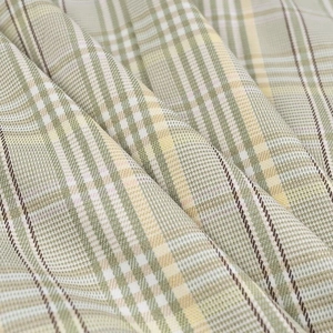 Close-up of green and beige plaid fabric showing the woven texture and detail of the suit