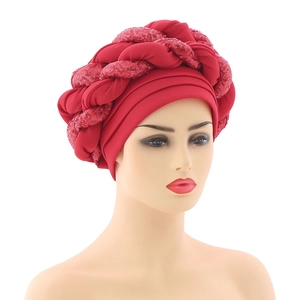 Detailed close-up of red turban featuring woven layers and sparkling sequin accents