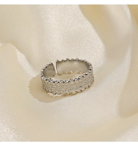 Macro view of adjustable silver steel ring with textured grain finish on silk