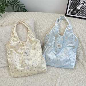 Close-up of pearl-finish silk tote bags with cute bear prints and velvet texture