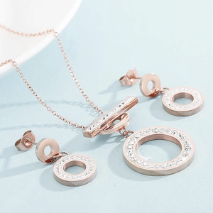 Macro shot of rose gold jewelry set featuring crystal circular pendant and matching earrings