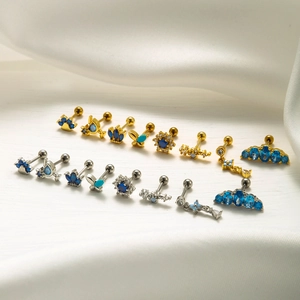 Collection of blue zircon cartilage studs with flower and crown shapes in gold and silver
