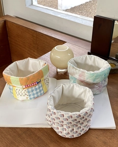Three patterned fabric storage baskets with floral and plaid designs for home organization