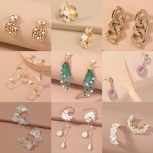 Detailed close-up of various vintage gold matte snake-style and floral earring sets