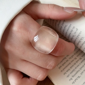 Close-up of transparent geometric resin ring with a clear square-cut design on a model