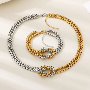 Detail view of two-tone gold and silver interlocking knot necklace and bracelet jewelry set