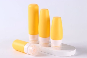 Macro view of 100ml and 60ml yellow silicone travel bottles with white flip caps