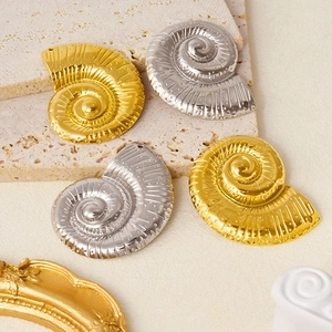 Detailed view of four conch shell charms in gold and silver for DIY jewelry making