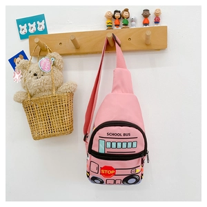Detail of pink cartoon school bus chest bag for kids in a warm home decor setting