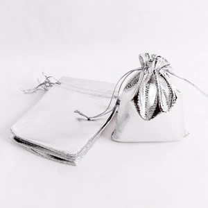 Macro view of metallic silver drawstring jewelry pouches with a polished finish