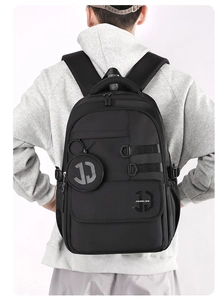 Rear view of model wearing a black large capacity nylon backpack for men with logo detail