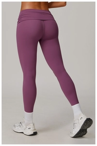 Detail view of purple yoga pants featuring a crossover high-waisted ribbed waistband design
