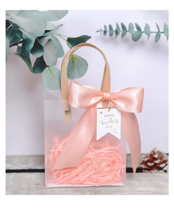 Close-up of frosted gift bag with pink ribbon bow and Happy Teacher's Day tag