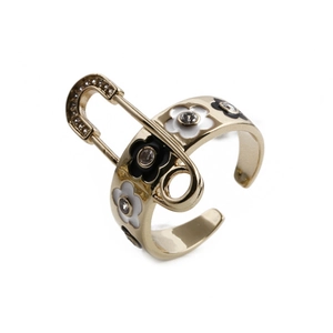 Détail de la bague trombone avec motif marguerite et placage en or sur fond blanc